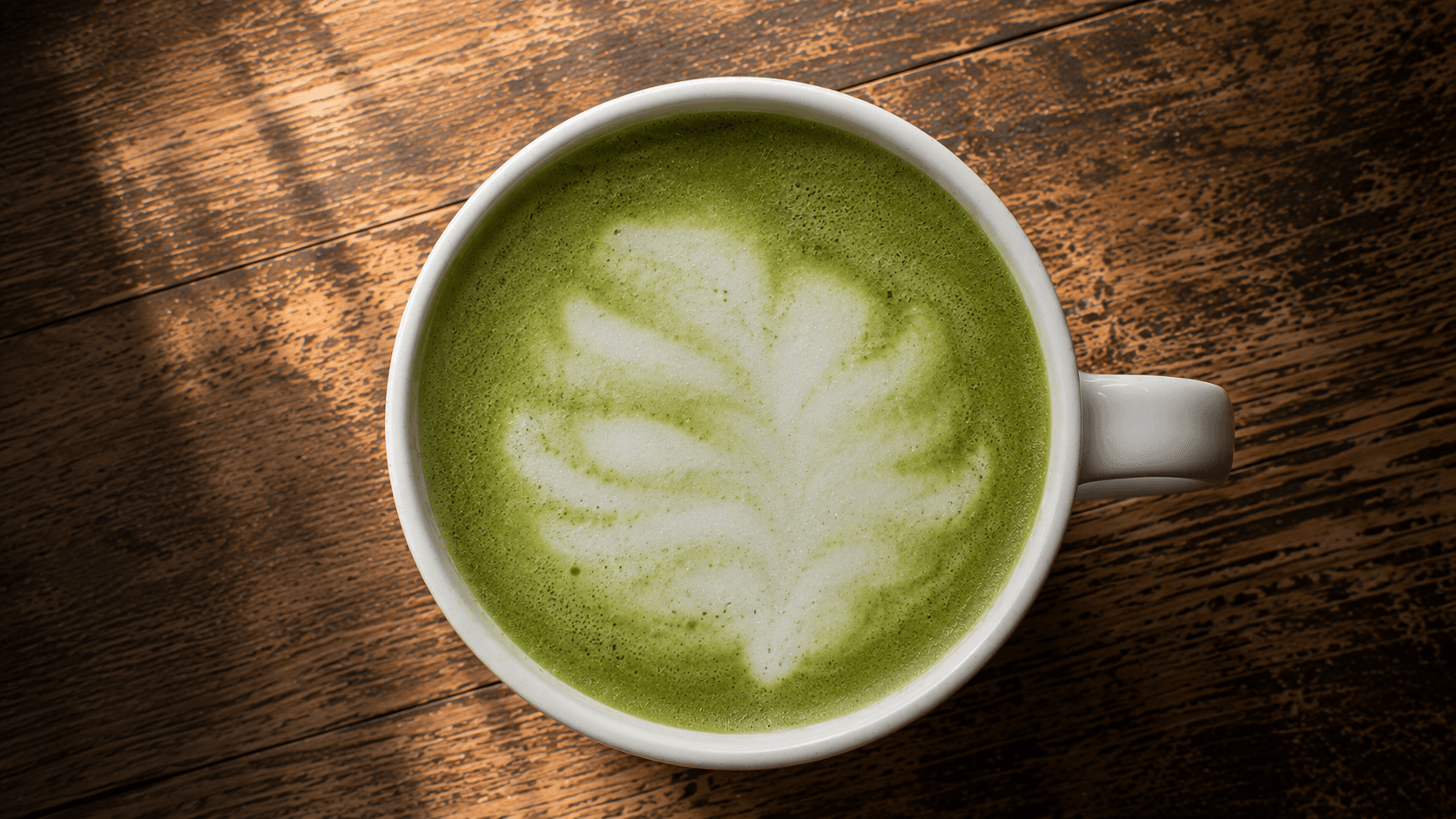 Matcha latte art attempt with fuzzy undefined shape and low contrast — common beginner mistake