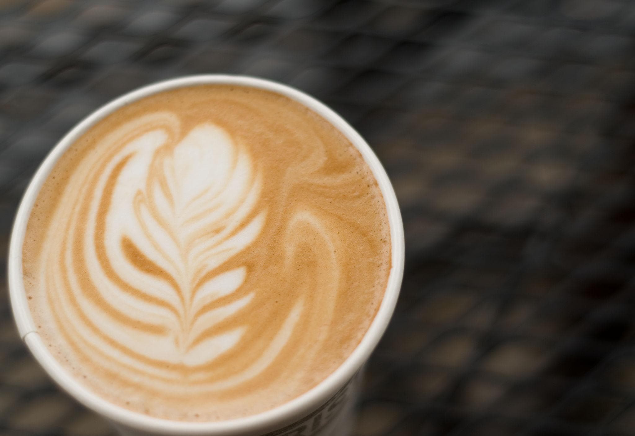 Latte art rosetta with chaotic wiggle and off-center pull-through — common intermediate mistake